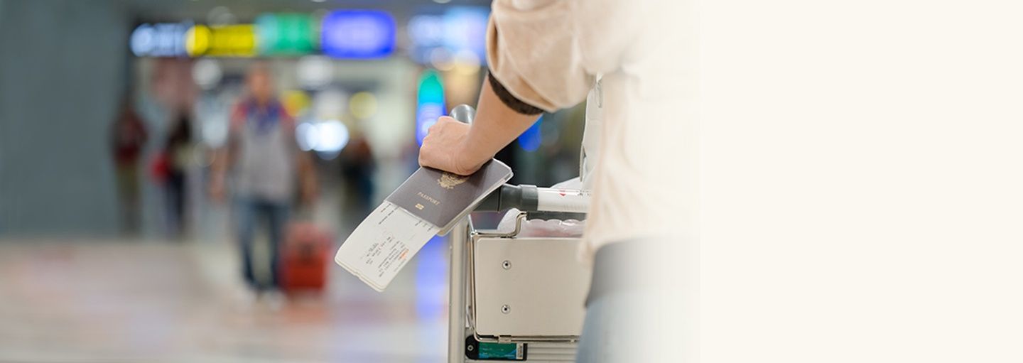 Hand holding passport with boarding passes at airport immigration checkpoint